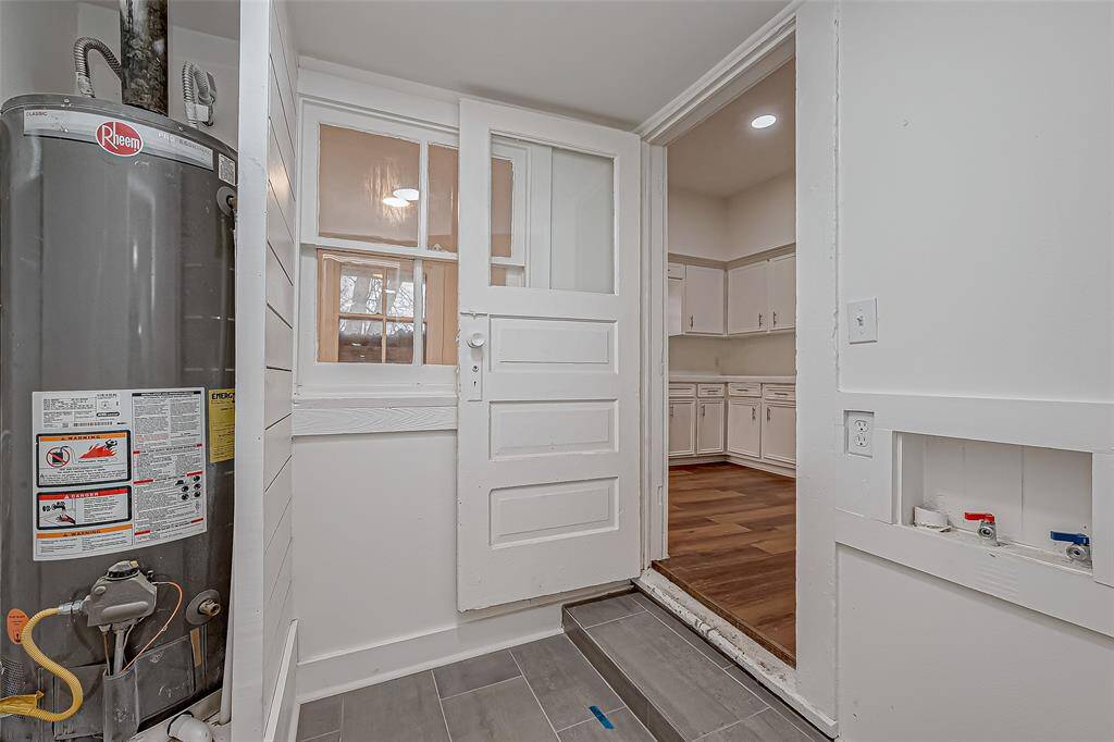 Situated between the kitchen and bathroom, the utility area provides dedicated space for laundry needs. Designed for efficiency, it features designated spots for a washer and dryer while maintaining an open feel with glass paneling that connects to adjacent areas.