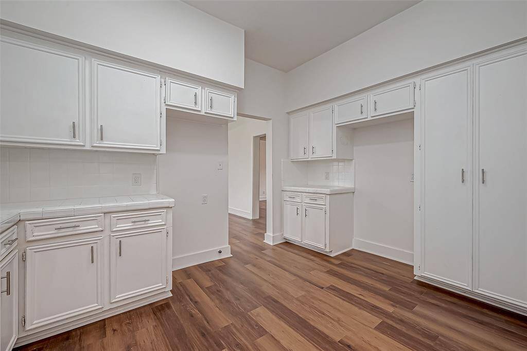 From this view, the kitchen’s smart design is evident, with extensive cabinetry providing ample storage. The well-placed lighting enhances both functionality and aesthetics, making meal prep and gatherings effortless at any time of day.
