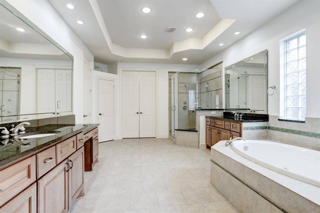 OVERSIZE WALK-IN CLOSET IN PRIMARY SUITE WITH LOADS OF HANGING AND SHELF SPACE - wood flooring