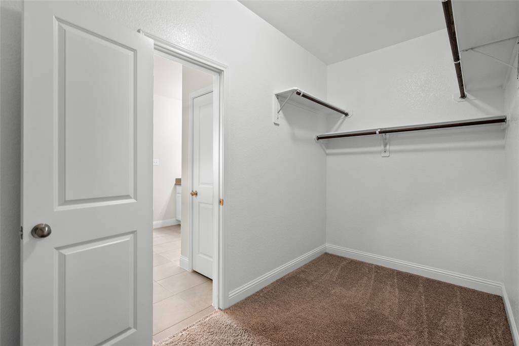 This is a walk-in closet with built-in shelving and hanging space