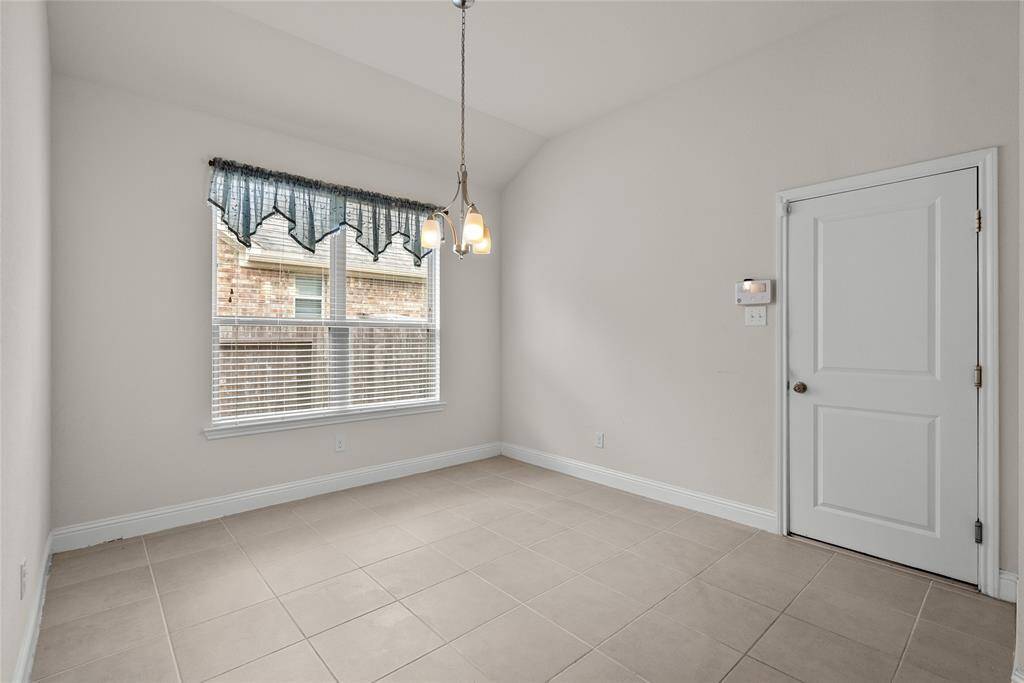 The Kitchenette featuring neutral wall colors, tile flooring,  leading to the garage