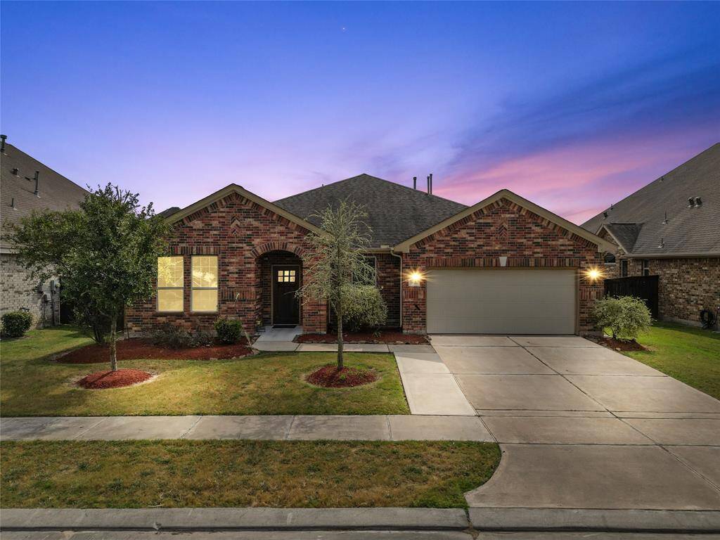 Welcoming brick TWO -story facade with manicured landscaping and a spacious two-car garage