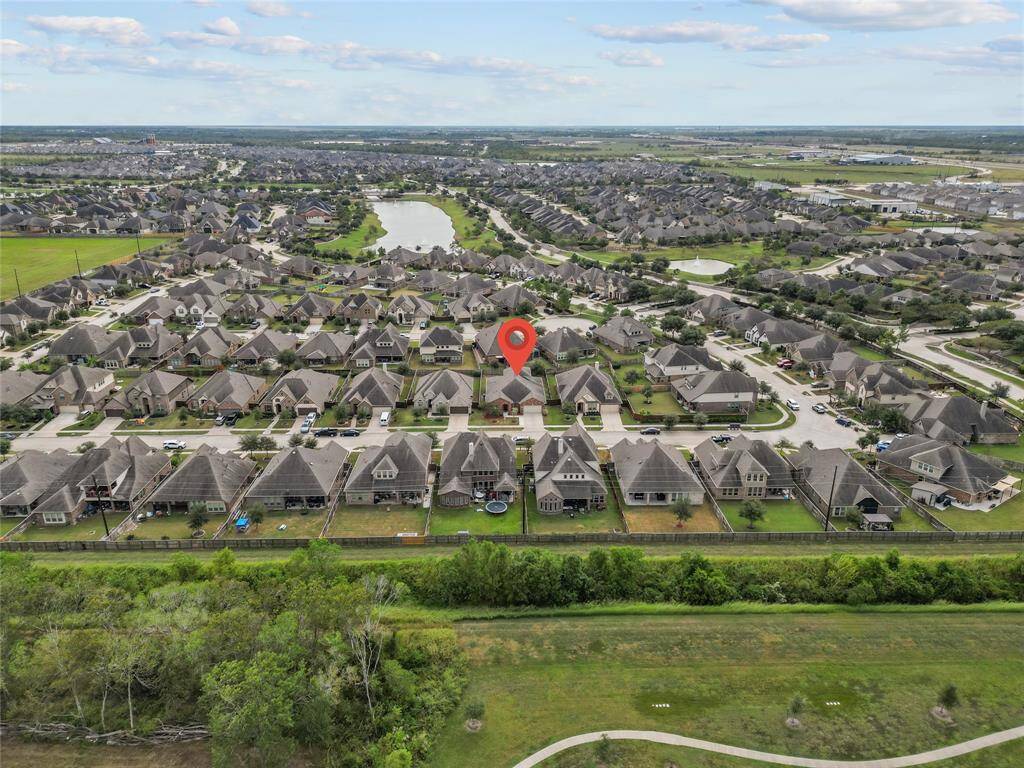 This aerial image showcases a suburban neighborhood well-spaced family homes, featuring ton of large lakes, providing a scenic view for surrounding properties. The community is well- established with ample green spaces.