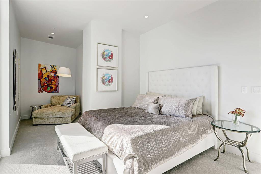 The master suite features high ceilings, recessed lighting, and great natural light.