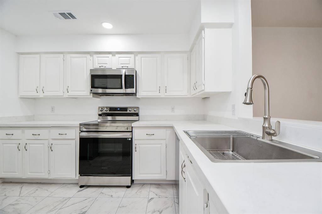 There's just something about a white kitchen that soothes and warms us! This urban culinary 'workshop" is stock full of cabinetry, up and down, lots of floor space, and a good looking farmhouse style stainless steel sink, with a great view from there to the open living space.