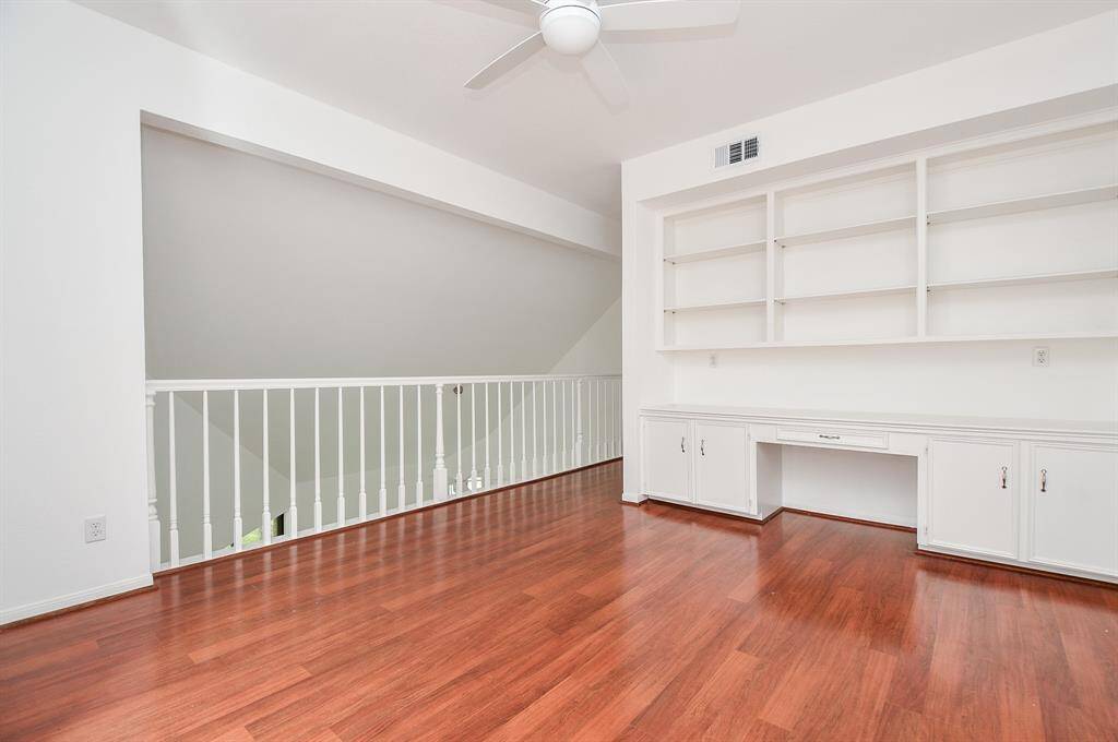 Up here on the huge 2nd 'game room' level, you'll love this built-in, wall-wide shelving/desk unit, with shining wood ? floors/ wood-look tile? laminate?