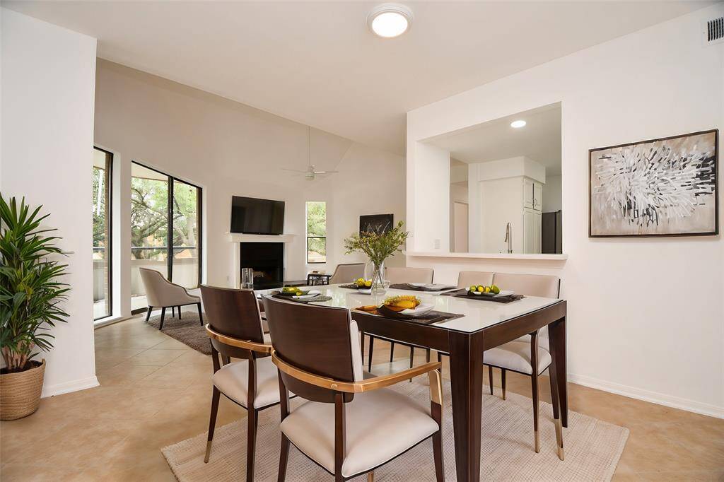 Great natural light (patio doors, left) shines on this living area, with divine fireplace and easy access to kitchen, right.