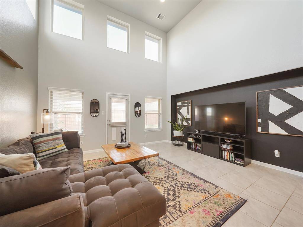 Bright, spacious, and inviting! This open-concept living room boasts soaring ceilings, modern finishes, and a seamless flow into the kitchen—perfect for entertaining or cozy nights in.