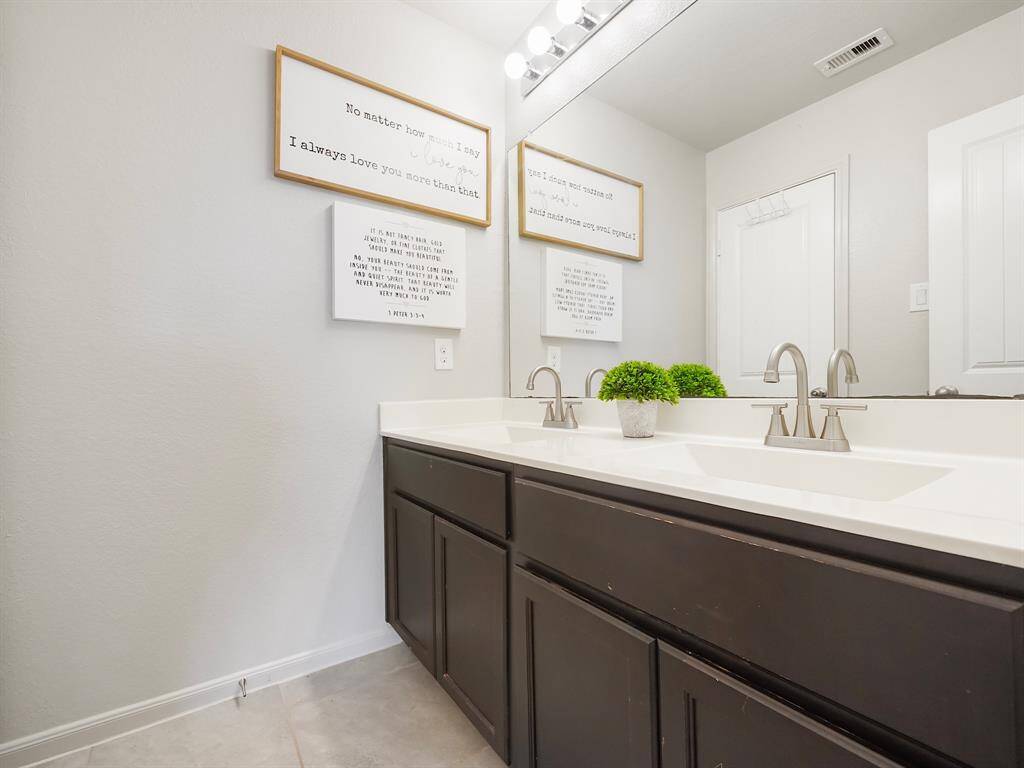 The upstairs bathroom features a stylish double sink vanity, providing ample space and convenience for busy mornings.