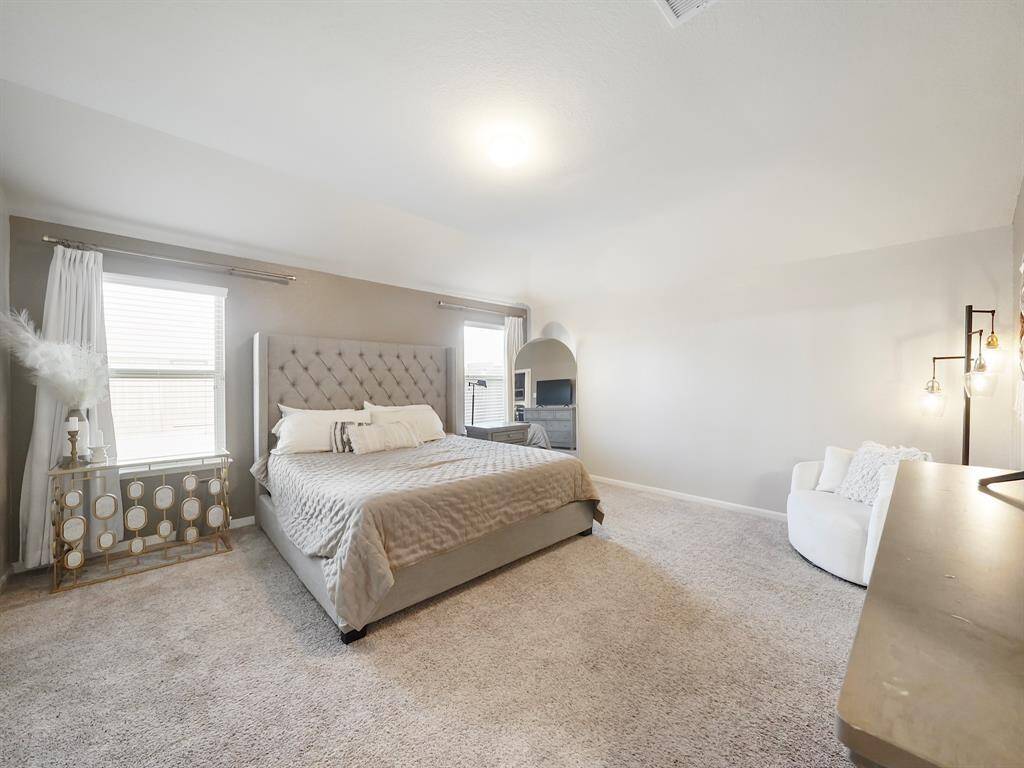 This large primary bedroom offers a peaceful retreat with ample space and natural light. The in-suite bath features a soaking tub, walk-in shower, and a generous walk-in closet, providing both comfort and convenience.