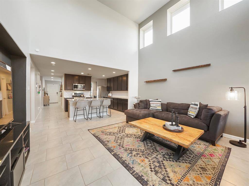 Step into this stunning open-concept living room, seamlessly flowing into the kitchen for the perfect blend of style and functionality. With soaring ceilings, abundant natural light, and modern touches, this space is ideal for both relaxing and entertaining!