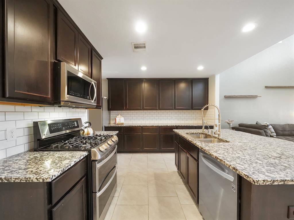 featuring abundant storage with sleek cabinetry, spacious countertops, and a large kitchen island that provides additional workspace and seating.