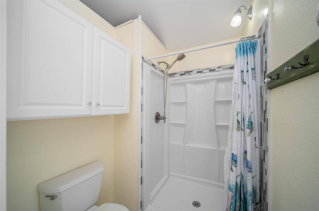 A step-in shower with a removable shower head is a perfect set up for this beach house.