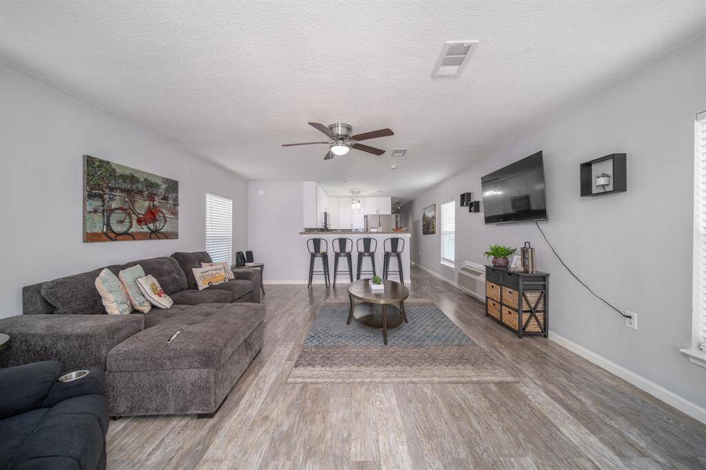 This lovely welcome announces beautiful vinyl plank floors that connect the family room, dining area, and kitchen.