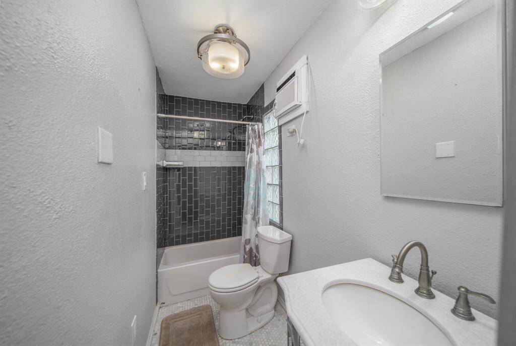 This lovely bath features updated light fixtures and a tile surround tub and shower combination.