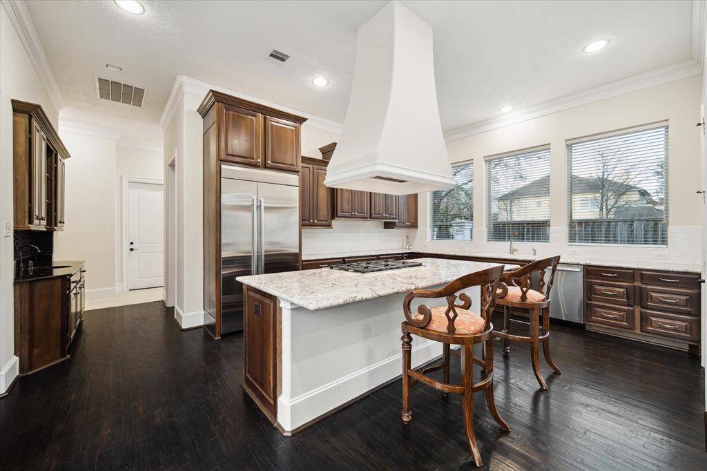 View showing the Kitchen with nearby built-in Butler's Pantry (glass/stained wood cabinet with drawers), adjacent walk-in Pantry with shelving. 1/2 bath, Utility Room, Garage Door entry and secondary Back Staircase.