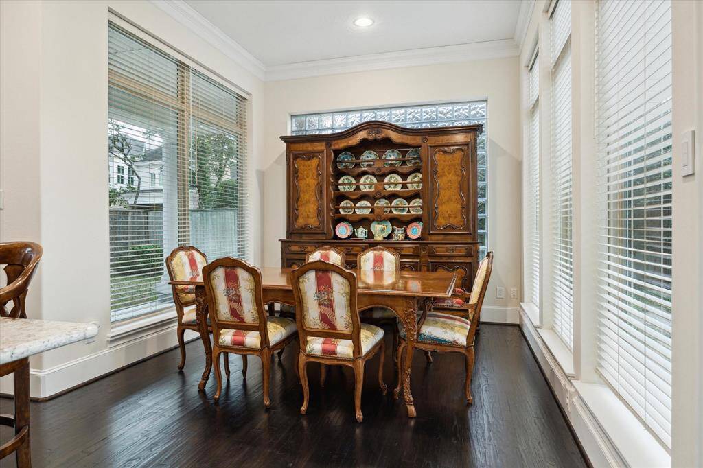 Adjacent to the Kitchen is the BREAKFAST ROOM (11 X 10) with its stained wood flooring, crown/base molding, glass block wall, five windows with blinds, recessed lighting.