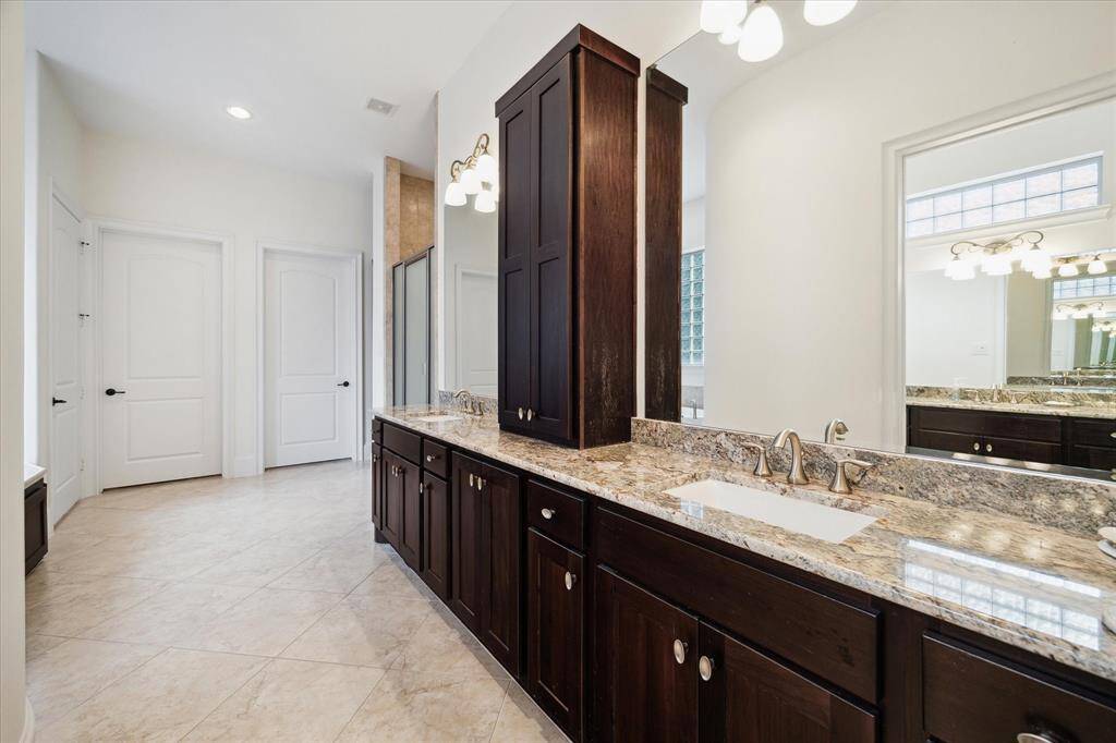 What a great PRIMARY BATH (19 X 16)  with its tile flooring, recessed lighting, dual sinks with cabinets/drawers below, granite counters/backsplash, built-in linen storage, , mirrors with decorative light sconces,private water closet, Royal spa tub with glass block accent wall, additional private water closet with sink, glass block walk-in shower, dual closets.