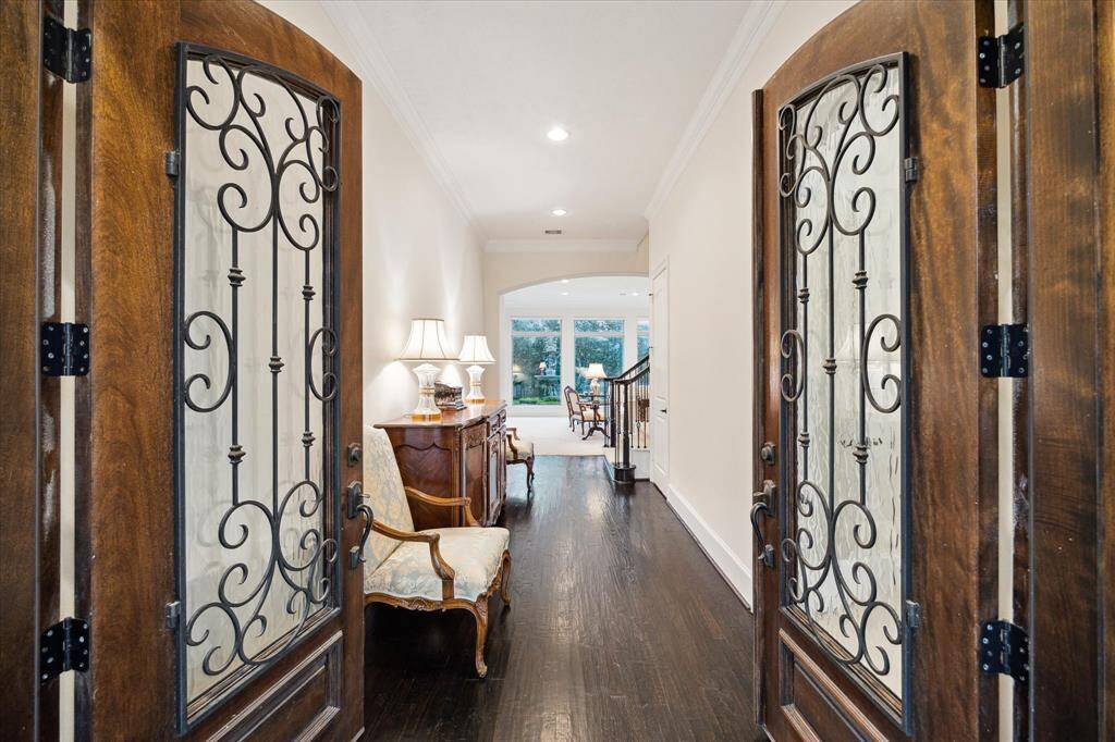 A handsome wood/glass/wrought iron double entry door leads to the welcoming ENTRY HALL (22 X 7) with its stained wood flooring, crown/base molding, painted walls, recessed lighting, storage room/coat closet, Stairway and opening to the Study, Living Room and Dining area.