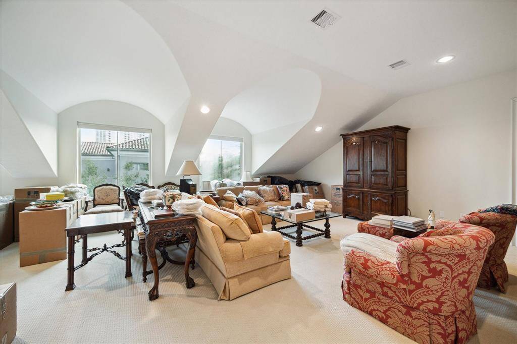 A spacious second floor GAME ROOM with its carpeted flooring, base molding, recessed lighting, door to floored attic space, two dormer windows in one portion of the room (21 X 20) and one dormer window in smaller section of the room (13 X 15).