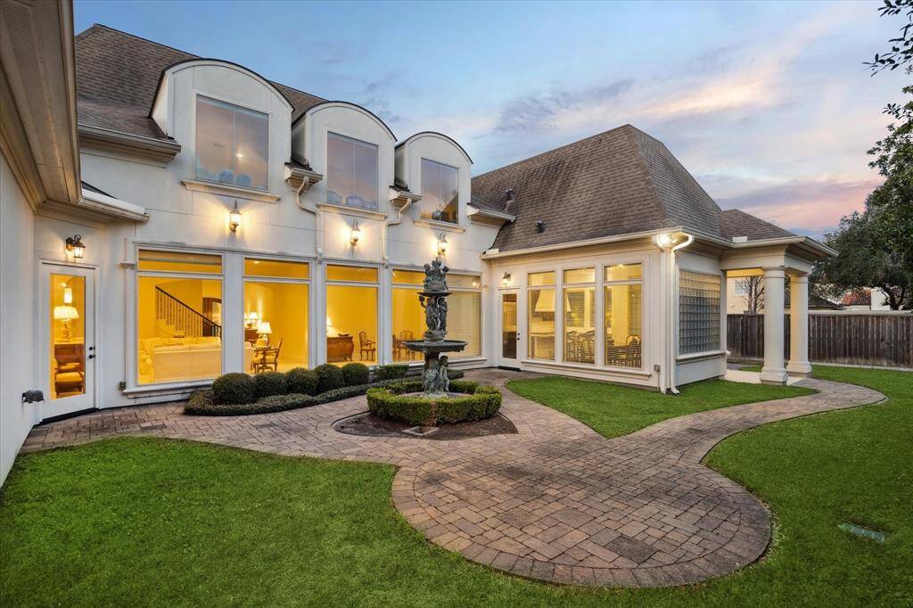 What a charming and serene BACKYARD GARDEN with its central fountain and manicured shrubbery surrounded by brick paver walkways and open grassed areas.  The Backyard is also large enough to accomodate a pool!