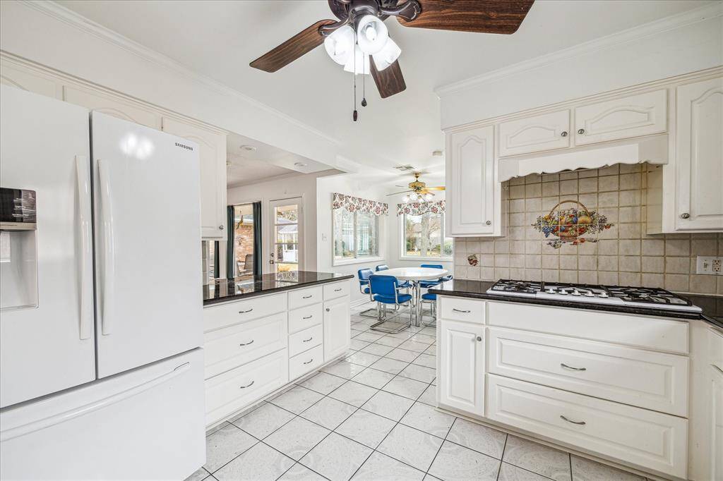 Bright, white kitchen with black granite counters.
