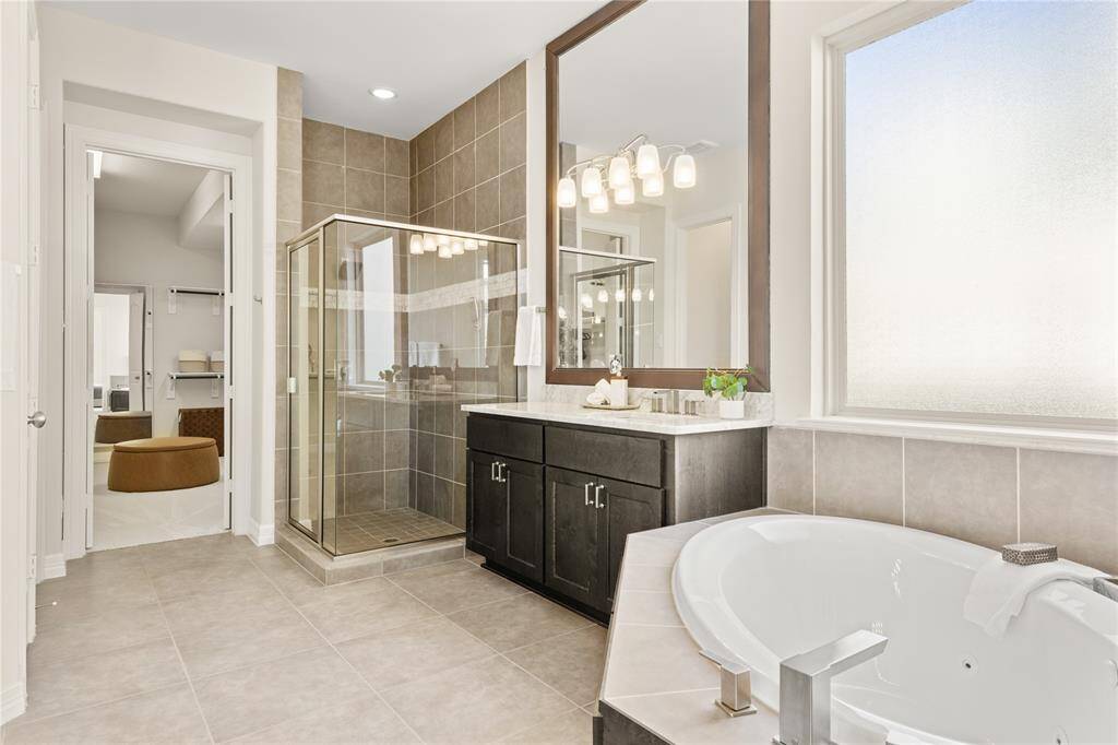 Expansive primary bathroom featuring a linen closet, walk-in closet, and private water closet.
