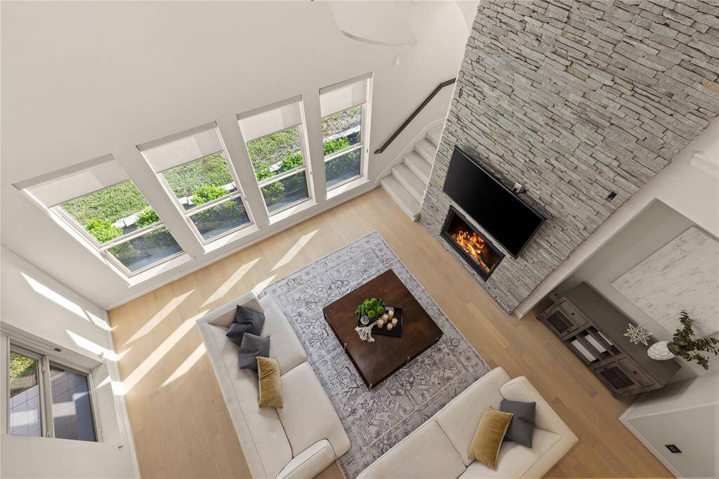 Stunning view of the living room from the second staircase landing, showcasing an elegant open space with abundant natural light.