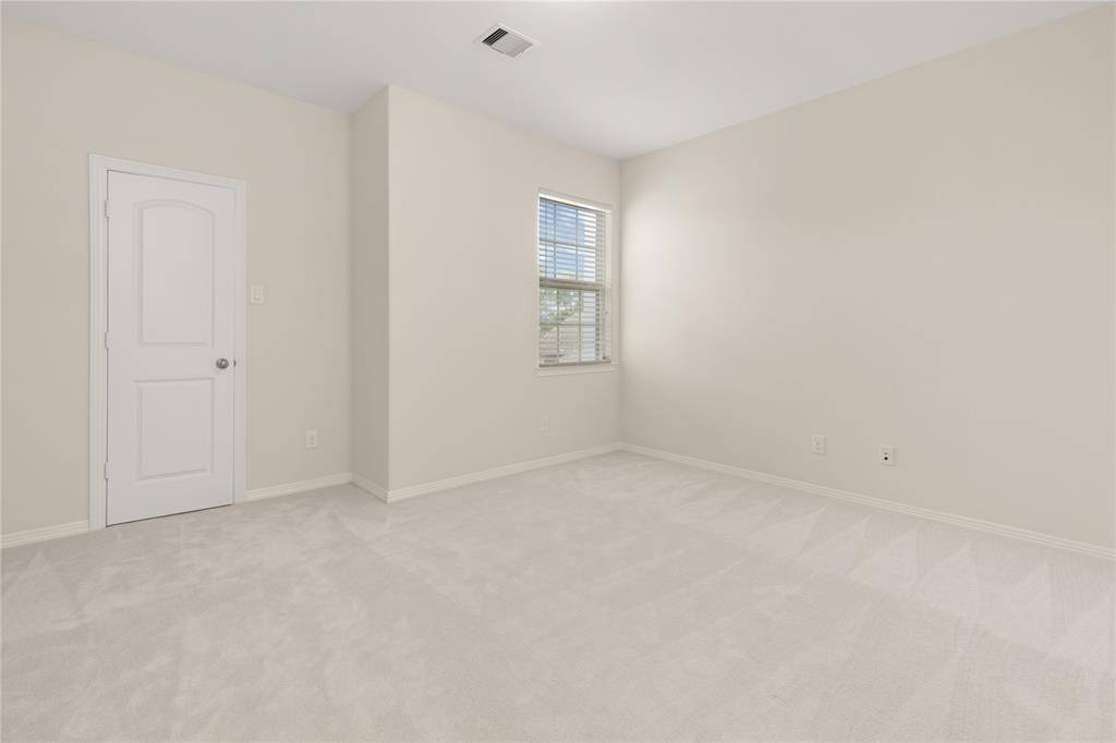Private secondary bedroom with a walk-in closet, conveniently located near the game and media rooms.