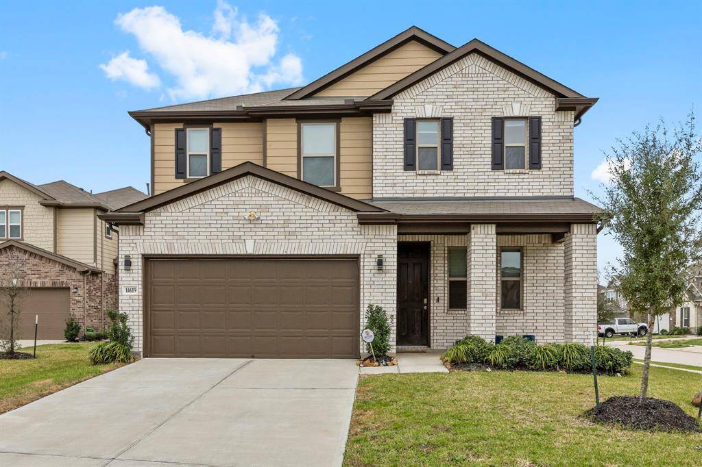 This is a modern two-story home with a brick facade and a two-car garage. It features a neatly landscaped front yard and a welcoming entrance. Located in a suburban neighborhood, it offers a spacious driveway and a clean, contemporary design.