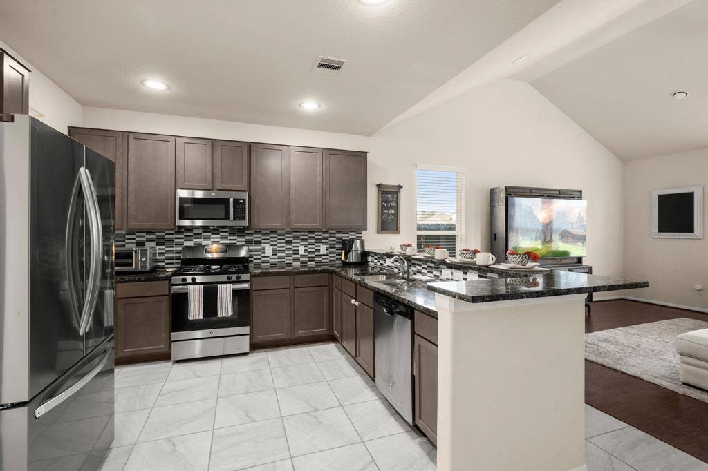 The stainless steel appliances give a beautiful contrast to the dark gray cabinets.  The refrigerator stays with the home.