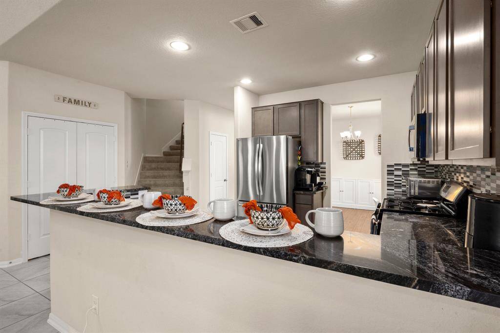 The kitchen is easy access to the staircase leading to the second story. The pantry to the left, is a large double doored closet containing shelves and organizers providing lots of storage and convenience.