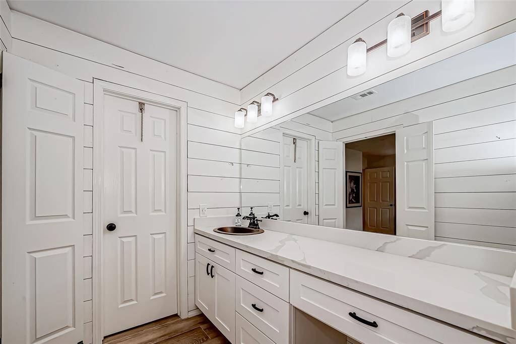 Primary bath with quartz countertop and vanity area