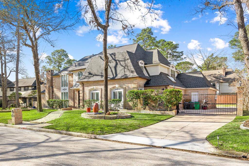 Charming two-story brick home with a striking dark roof and elegant design. Features include a beautifully landscaped front yard, circular driveway, large windows, and a gated entrance. Situated in a perfect family-friendly neighborhood.