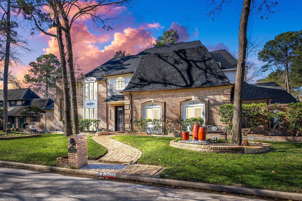 Experience the charm of this elegant two-story brick home, featuring a steep gabled roof and arched windows. With a welcoming curved brick walkway, mature trees, and stylish planters, this home is nestled in a serene, tree-lined neighborhood—your perfect retreat.