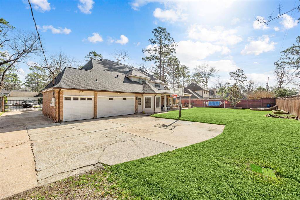 Discover a spacious backyard with a three-car garage, basketball hoop, and lush lawn. This brick home offers a fenced perimeter for privacy and abundant outdoor space for activities.