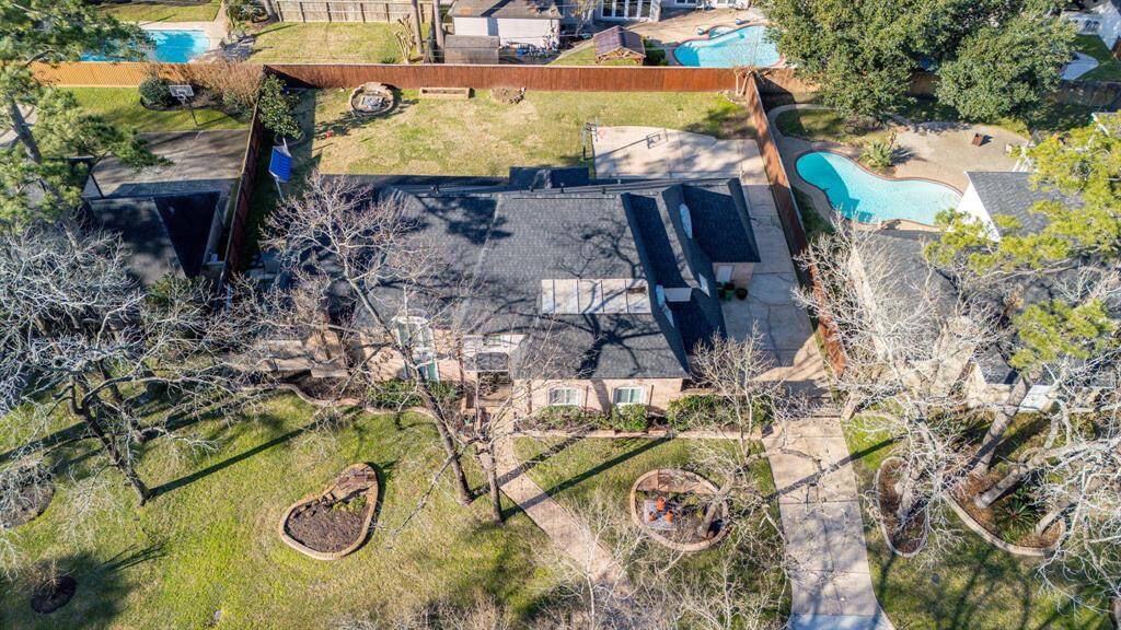 Experience this expansive, single-story home nestled among mature trees, featuring a lush backyard with a curved pool and plenty of space for outdoor fun. The inviting front yard boasts a landscaped garden and driveway, enhancing its charming curb appeal.
