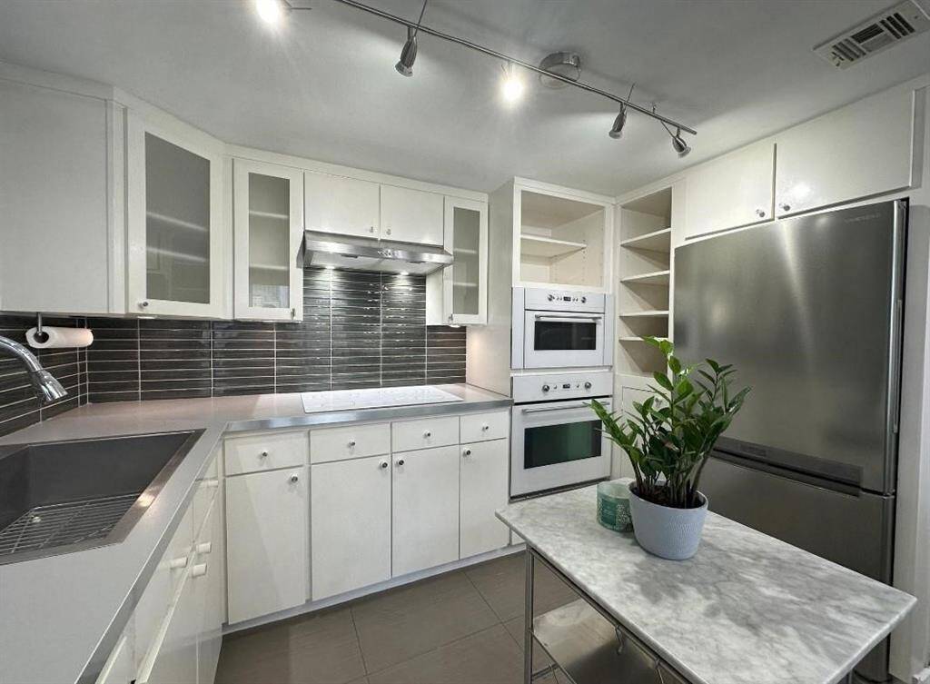 This stylish kitchen boasts clean lines, modern appliances, and plenty of cabinet space. The neutral color palette creates a timeless and sophisticated look.
