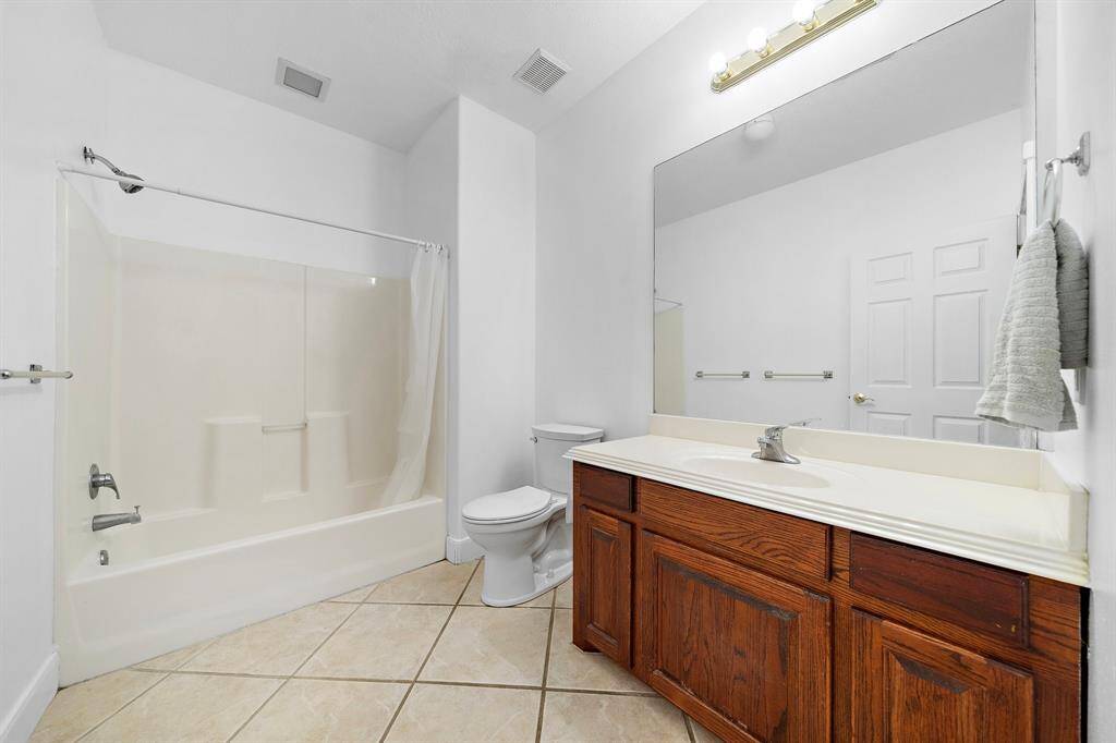 Clean bathroom with a shower-tub combination and a large vanity