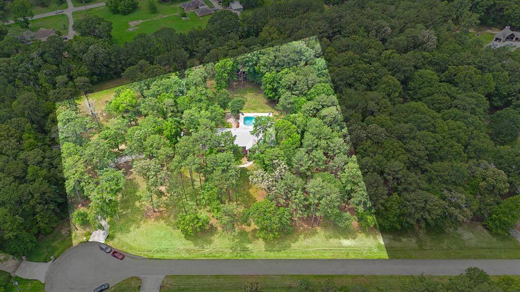 Aerial view of the property surrounded by dense trees.