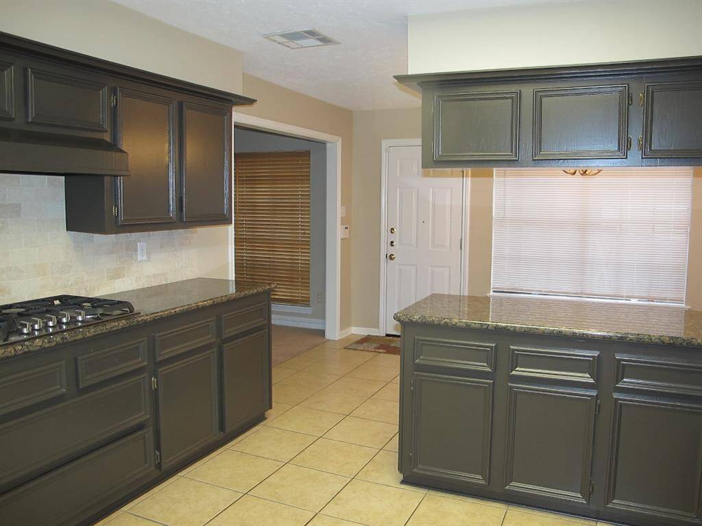 Standing in the doorway of the formal dining room, looking into the kitchen and breakfast room.  Door leads into the back yard and to the 2 car detached garage.