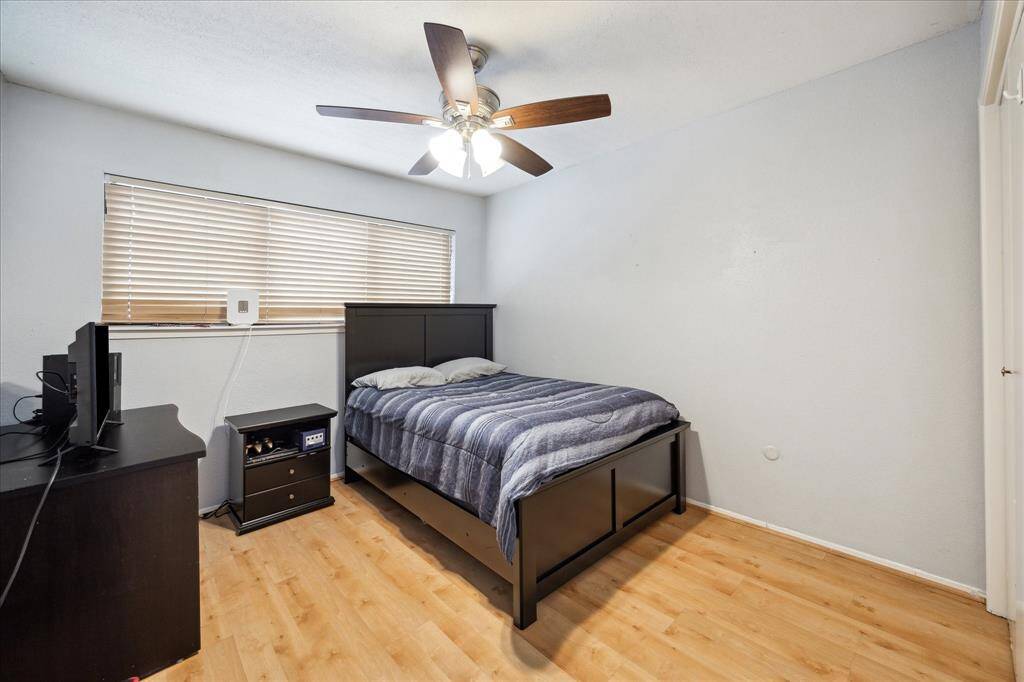 One of two secondary bedrooms. This room features windows with shades, a ceiling fan, and crown molding.