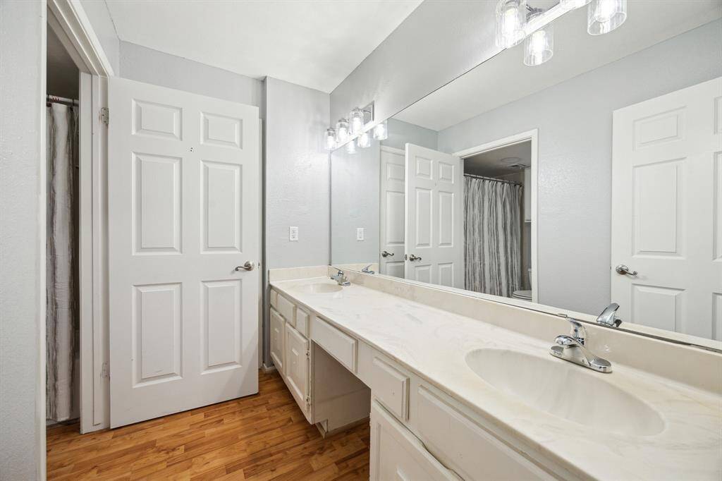 The shared secondary bedroom features dual sinks, a shower/tub combo, and under sink storage.