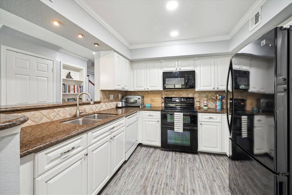 The kitchen features granite countertops, a double sink, double ovens, and plenty of cabinet space. Microwave, ovens, and refrigerator to stay.