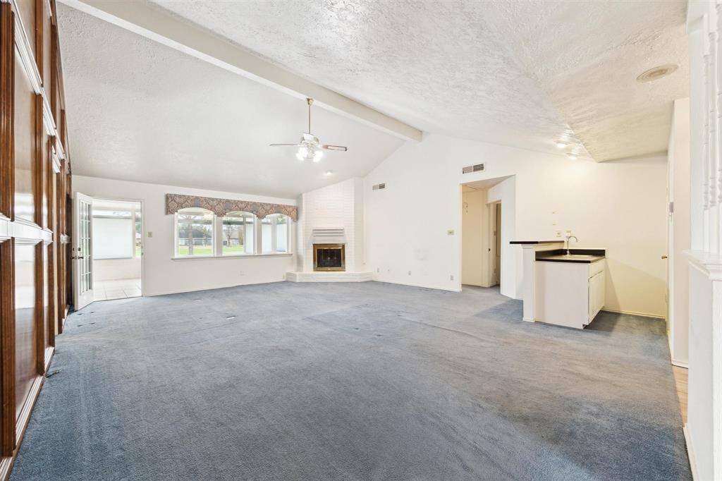 Spacious living room with Fireplace and view to the Sunroom and golf course.