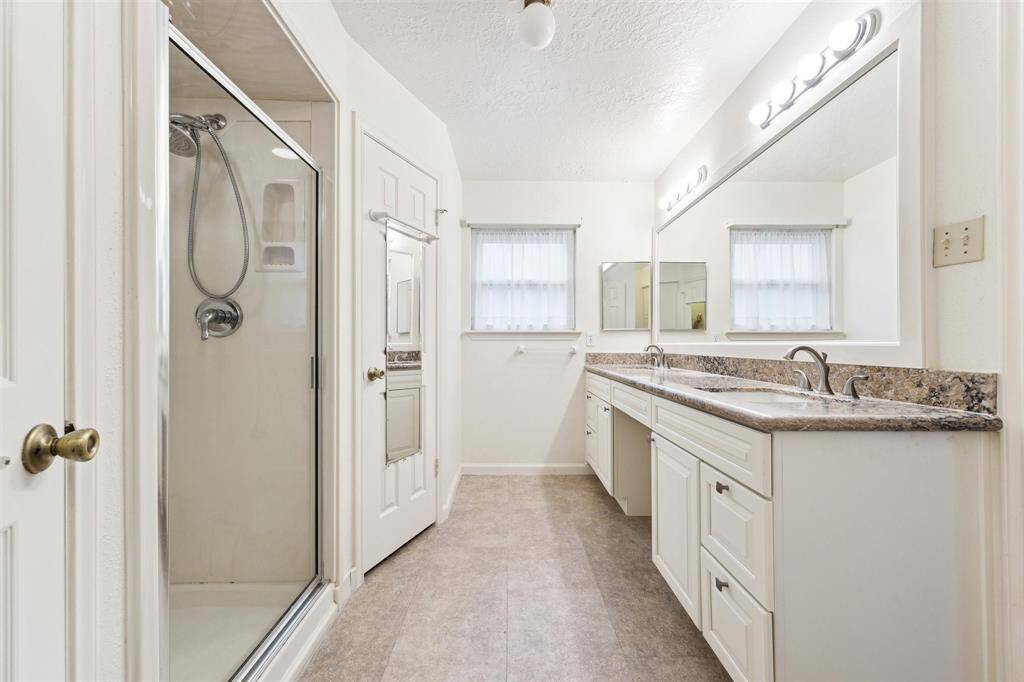 Primary bath with double sinks and dual closets.