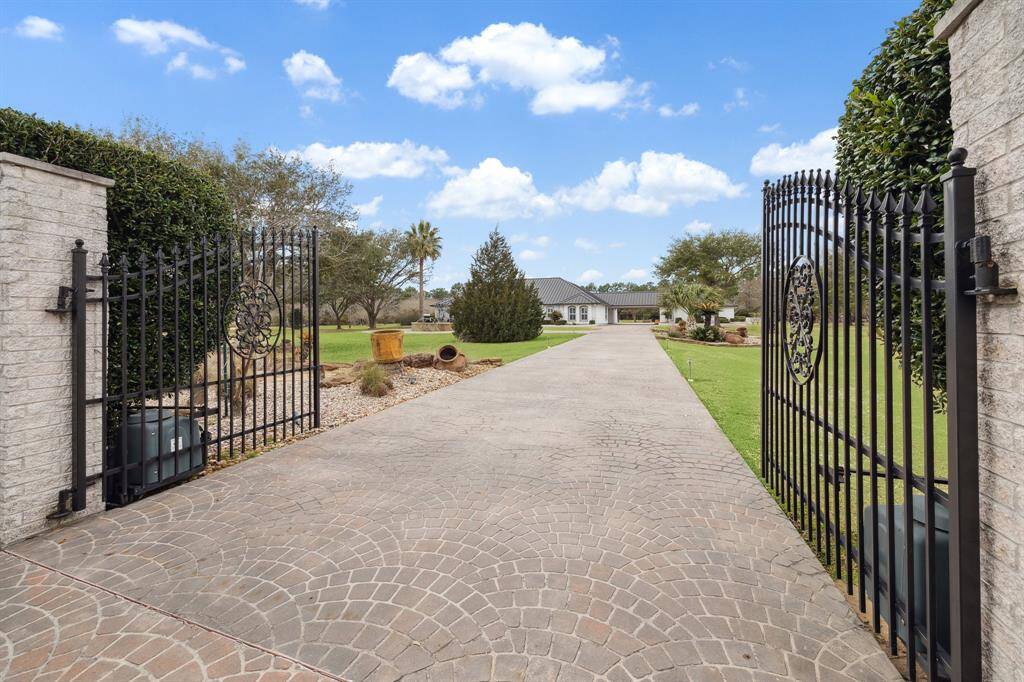 A secure and beautiful wrought-iron driveway gate ensures privacy.