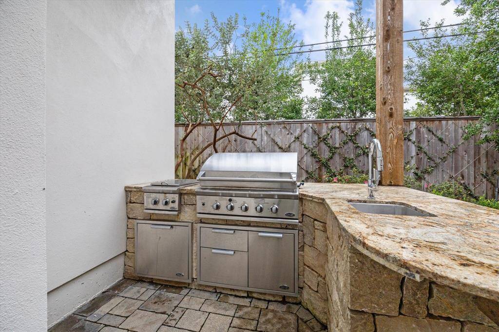 Summer kitchen with gas grill, single burner cooktop, sink and ample storage.  Could be relocated off exterior corner of family room, if preferred.