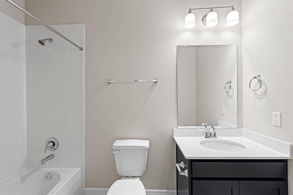 The secondary bath features tile flooring, white cabinetry and light countertops and a shower/tub combo. Perfect for accommodating any visiting family and friends.