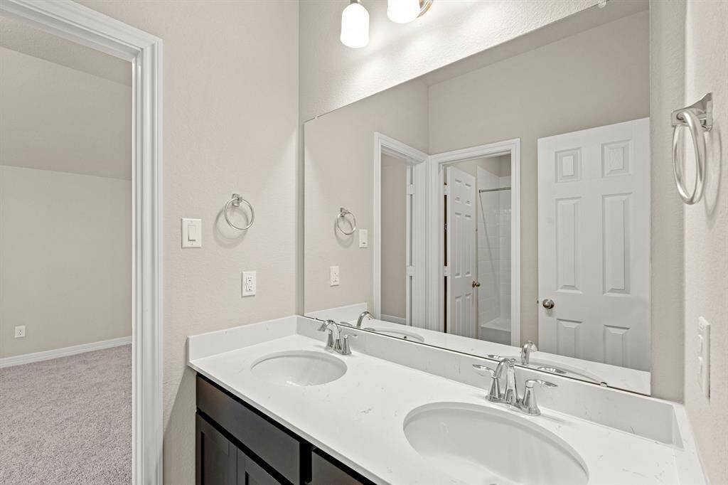 The secondary bath features tile flooring, white cabinetry and light countertops and a shower/tub combo. Perfect for accommodating any visiting family and friends.